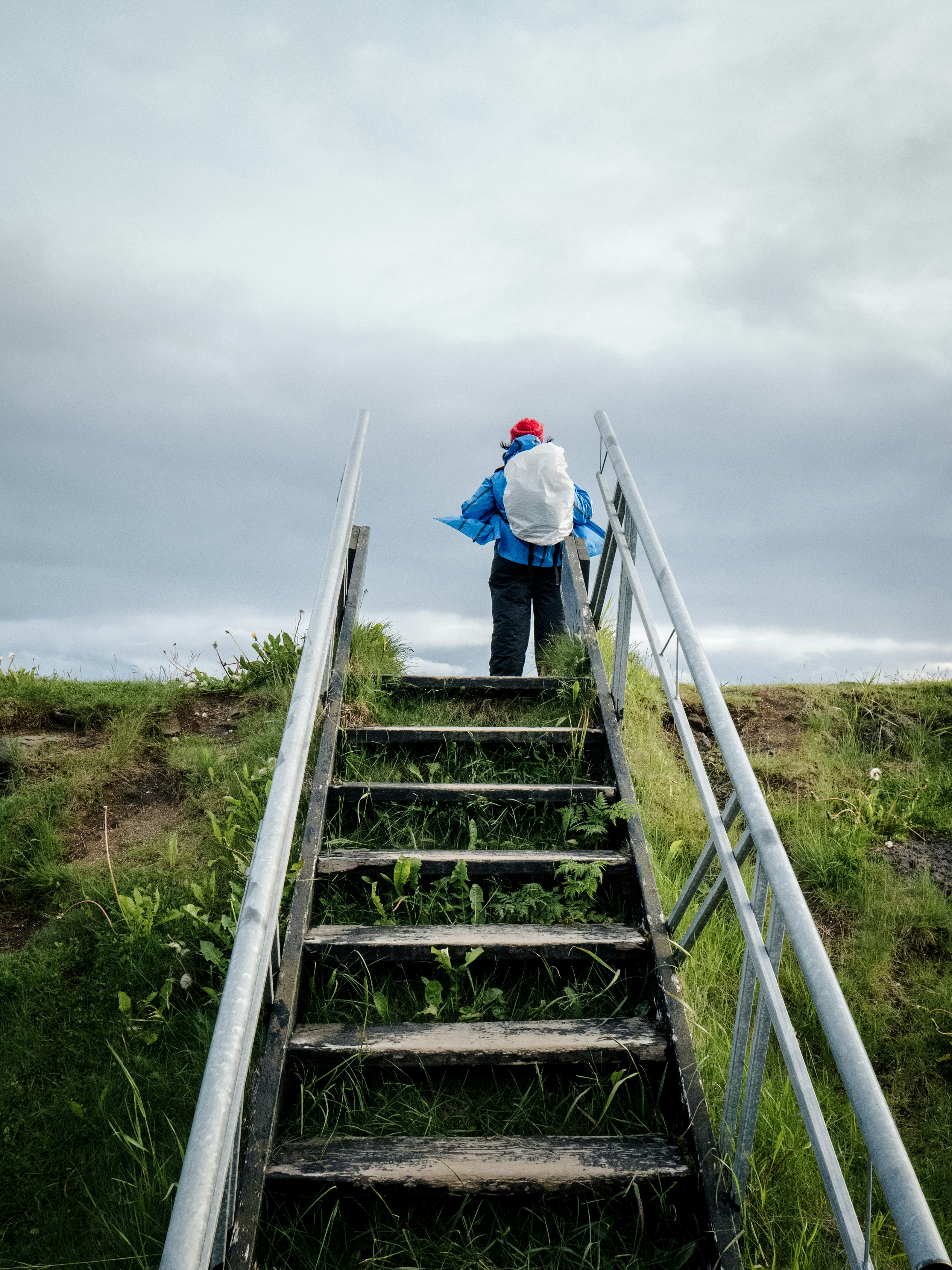 person in white jacket walking on gray concrete stairs